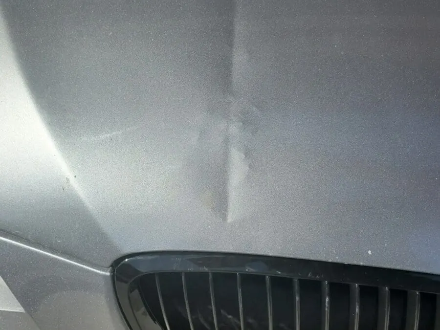 BMW hood with clearcoat stressed and high spots from sharp PDR tool pushed with too much force