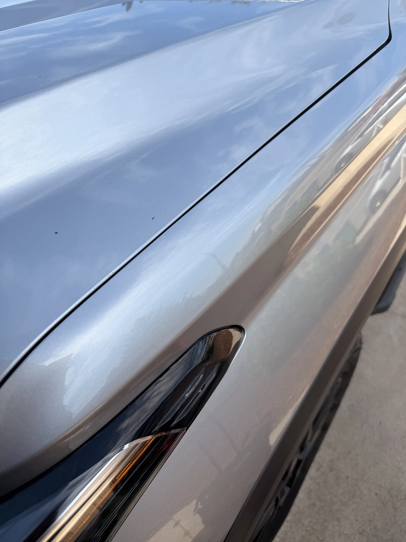 The repaired silver fender with straight reflections after paintless dent repair reset the DIY attempt