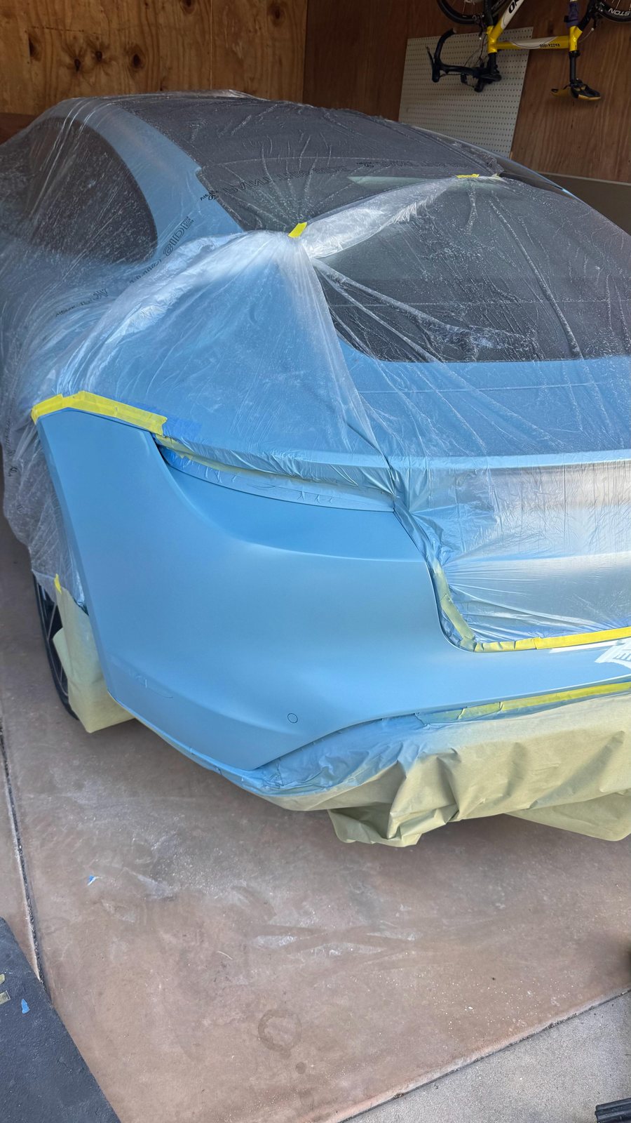 Porsche Taycan rear bumper masked off for a mobile refinish in San Diego