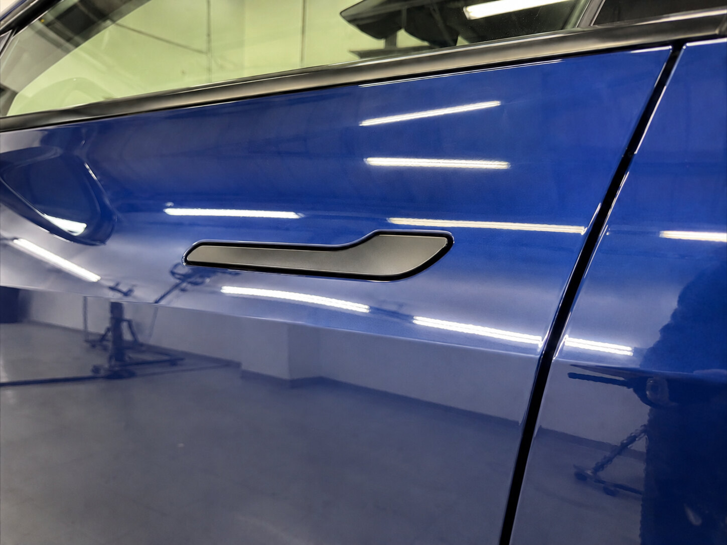 Tesla aluminum door after paintless dent repair, finish flawless